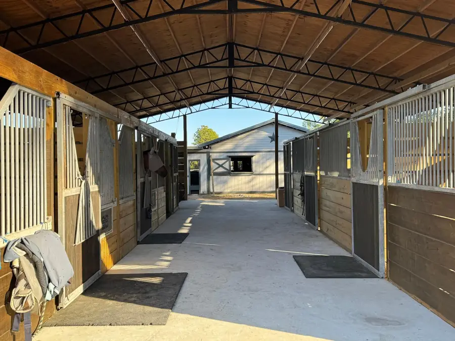Wide barn aisle lined with wooden stall fronts